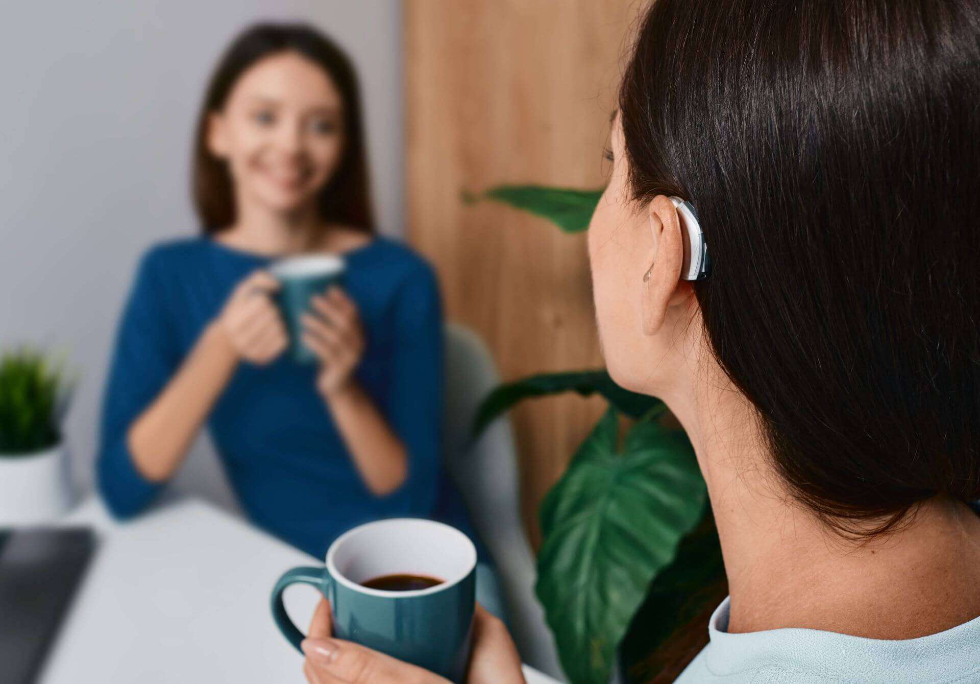 women drinking coffee with hearing aid